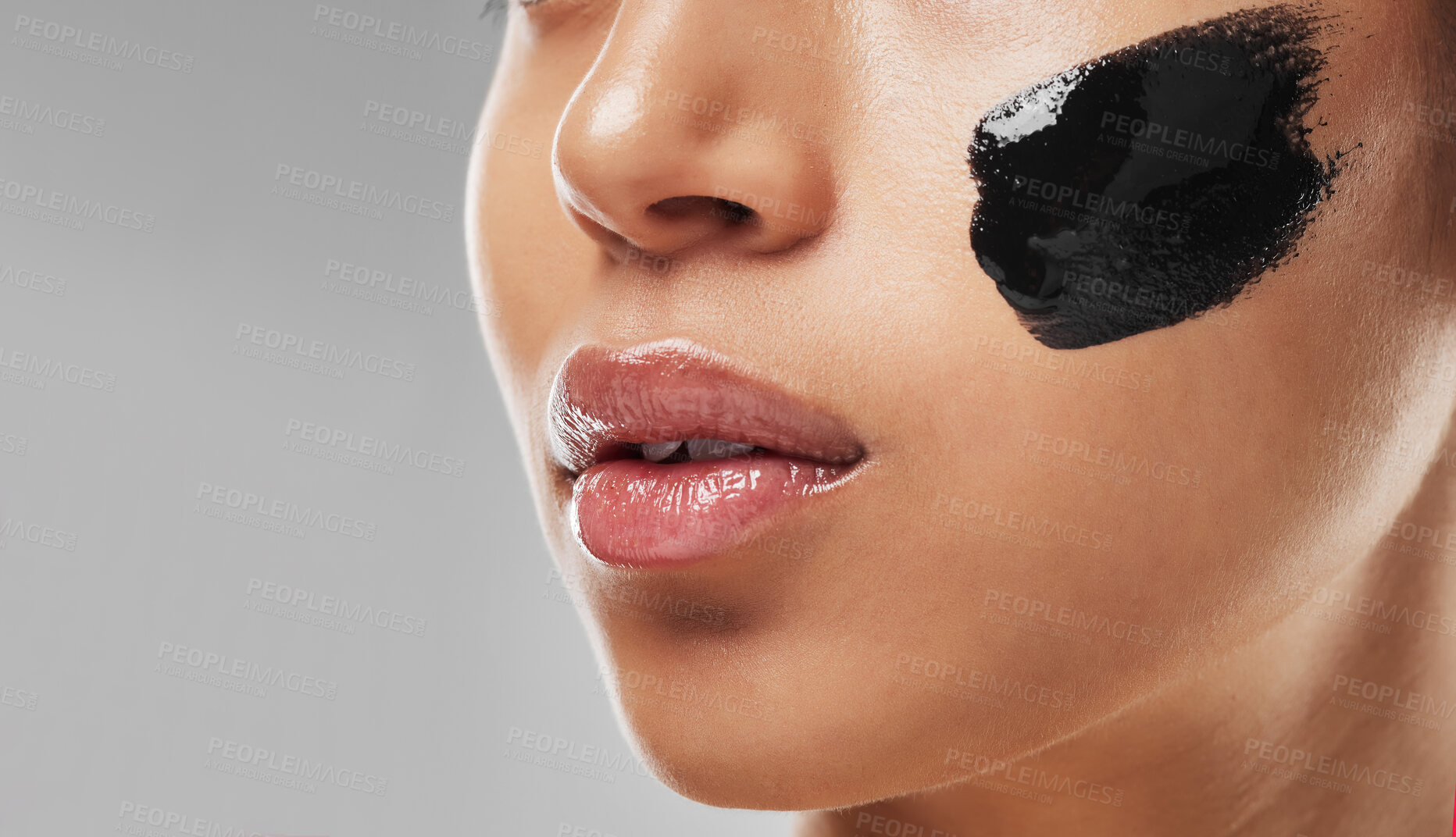 Buy stock photo Studio shot of an unrecognisable woman wearing some charcoal face mask against a grey background