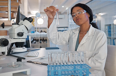 Buy stock photo Shot of a young female lab tech analysing a sample in her office
