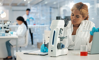 Buy stock photo Shot of a young woman making notes while working with samples