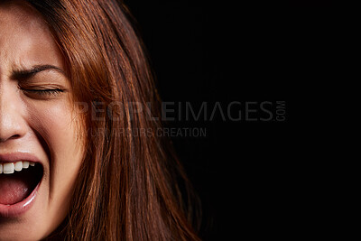 Buy stock photo Shot of a young woman experiencing mental illness against a black background
