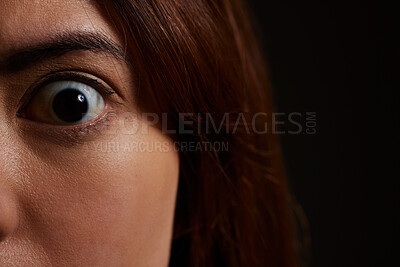 Buy stock photo Shot of a young woman experiencing mental illness against a black background