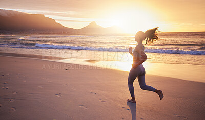 Buy stock photo Shot of a woman out for a run on the beach at sunset