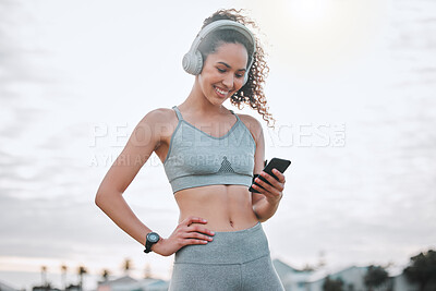 Buy stock photo Fitness, woman and phone with headphones outdoor for exercise music or tracking workout progress. Athlete, girl or happy with smartphone for listening to radio or streaming training podcast in nature