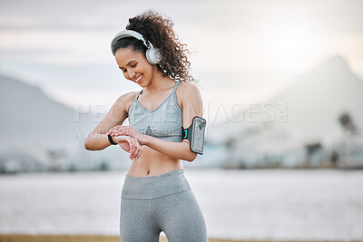 Buy stock photo Running, fitness and woman with time on beach listening to music, audio and radio for cardio workout. Sports, athlete and person with watch for exercise, marathon training and wellness outdoors