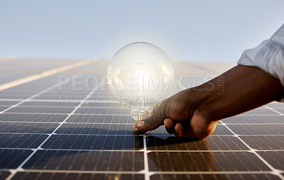 Buy stock photo Shot of a man holding a light bulb against a solar panel