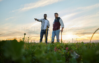 Buy stock photo Shot of two farmers standing on a farm during sunset