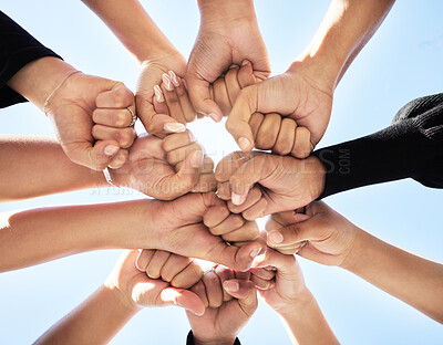 Buy stock photo Below, hands and fist bump outdoor for teamwork, strength or unity for synergy. Group, huddle or people connected for power, solidarity or trust in community for protest, empowerment or organization