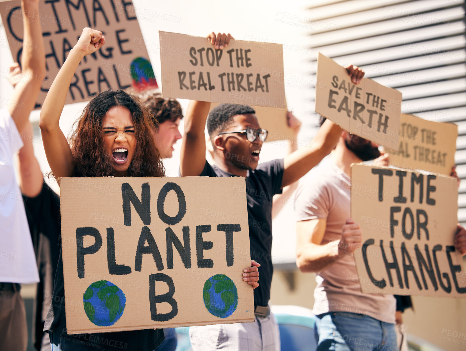 Buy stock photo Shot of a group of people holding up signs at a protest rally