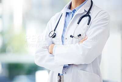 Buy stock photo Closeup shot of an unrecognisable doctor standing with her arms crossed in a hospital