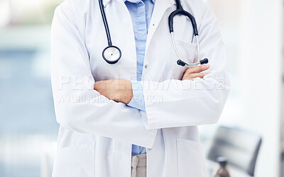 Buy stock photo Closeup shot of an unrecognisable doctor standing with her arms crossed in a hospital
