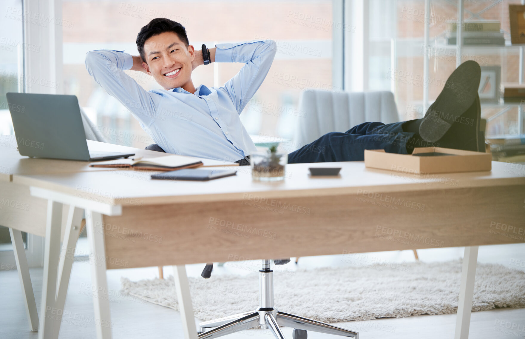 Buy stock photo Shot of a young businessman resting while working in a modern office