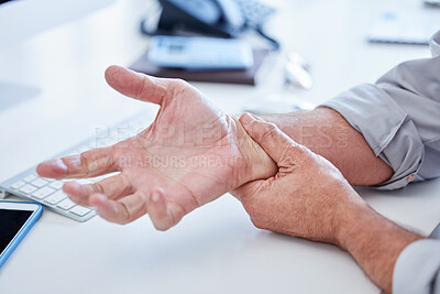 Buy stock photo Closeup shot of an unrecognisable businessman experiencing wrist pain while working in an office