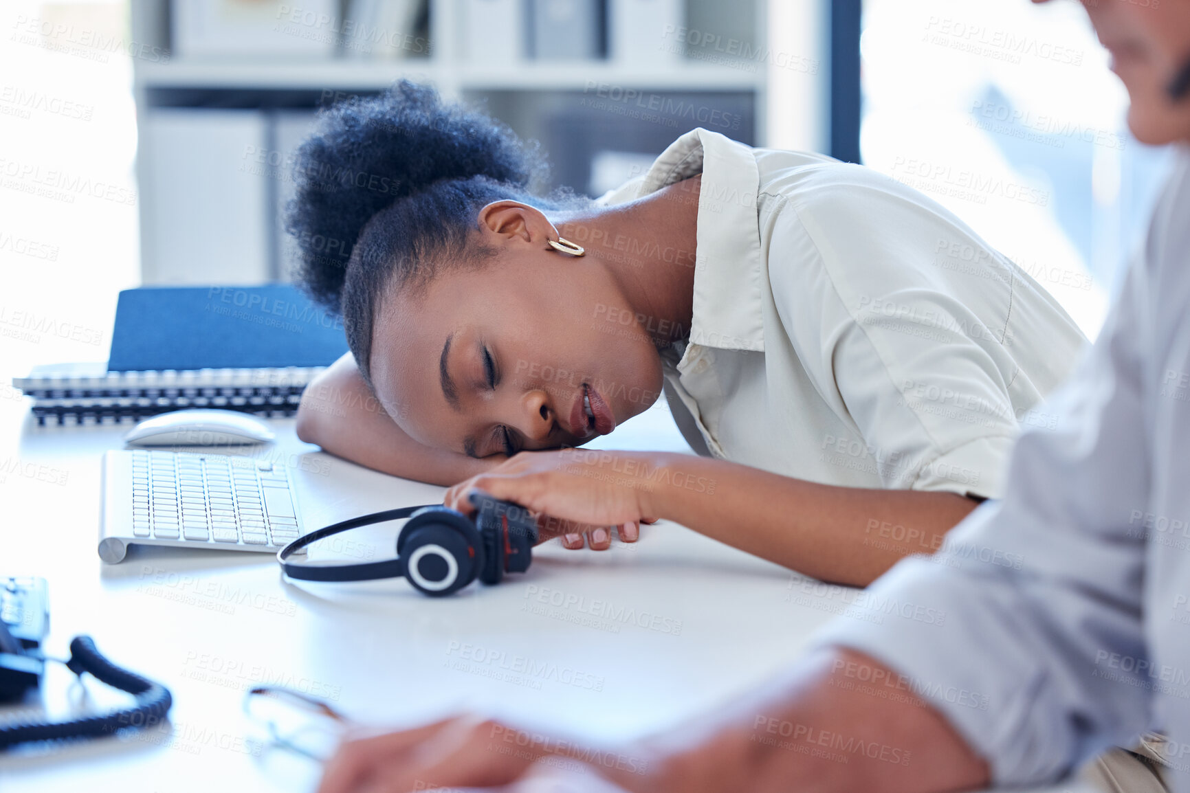 Buy stock photo Shot of a young call centre agent sleeping at her desk in an office