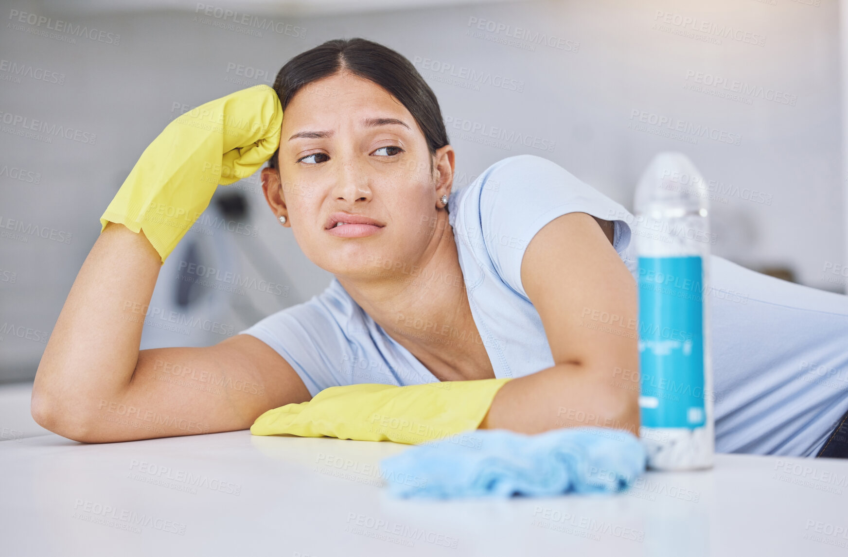 Buy stock photo Shot of a young woman looking unhappy while doing chores at home