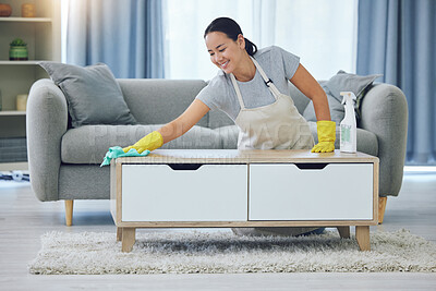 Buy stock photo Shot of a young woman wiping a table at home