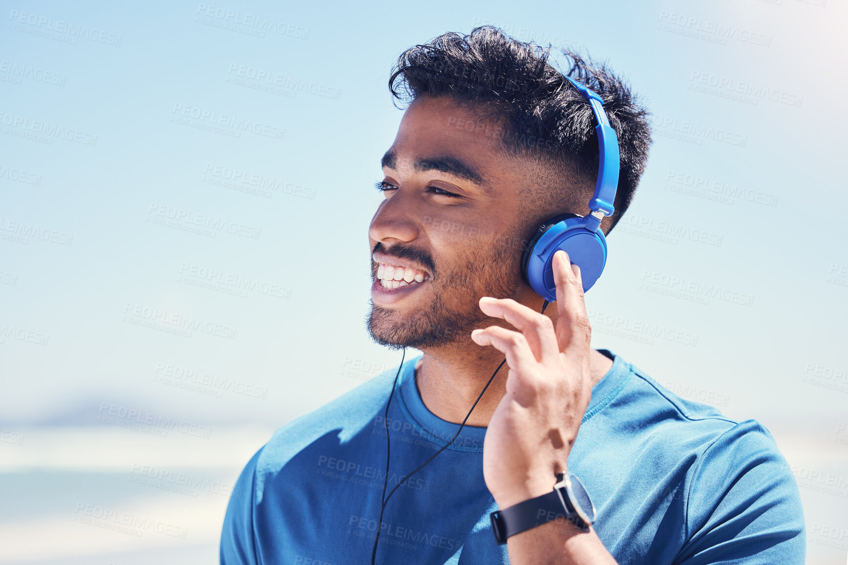 Buy stock photo Happy, man and music on beach for fitness or energy boost, motivation and exercise routine for wellness or health. Male person, thinking and headphones in nature for podcast and cardio playlist.