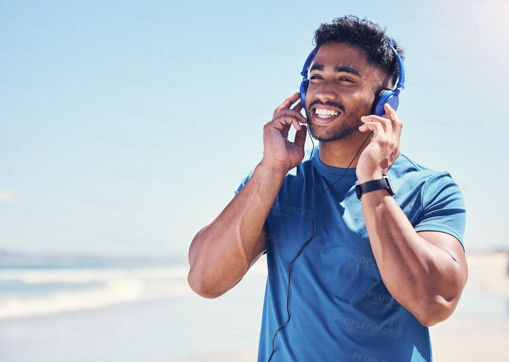 Buy stock photo Thinking, man and music on beach for fitness or energy boost, motivation and exercise routine for wellness or health. Male person, happiness and headphones in nature for podcast and cardio playlist.