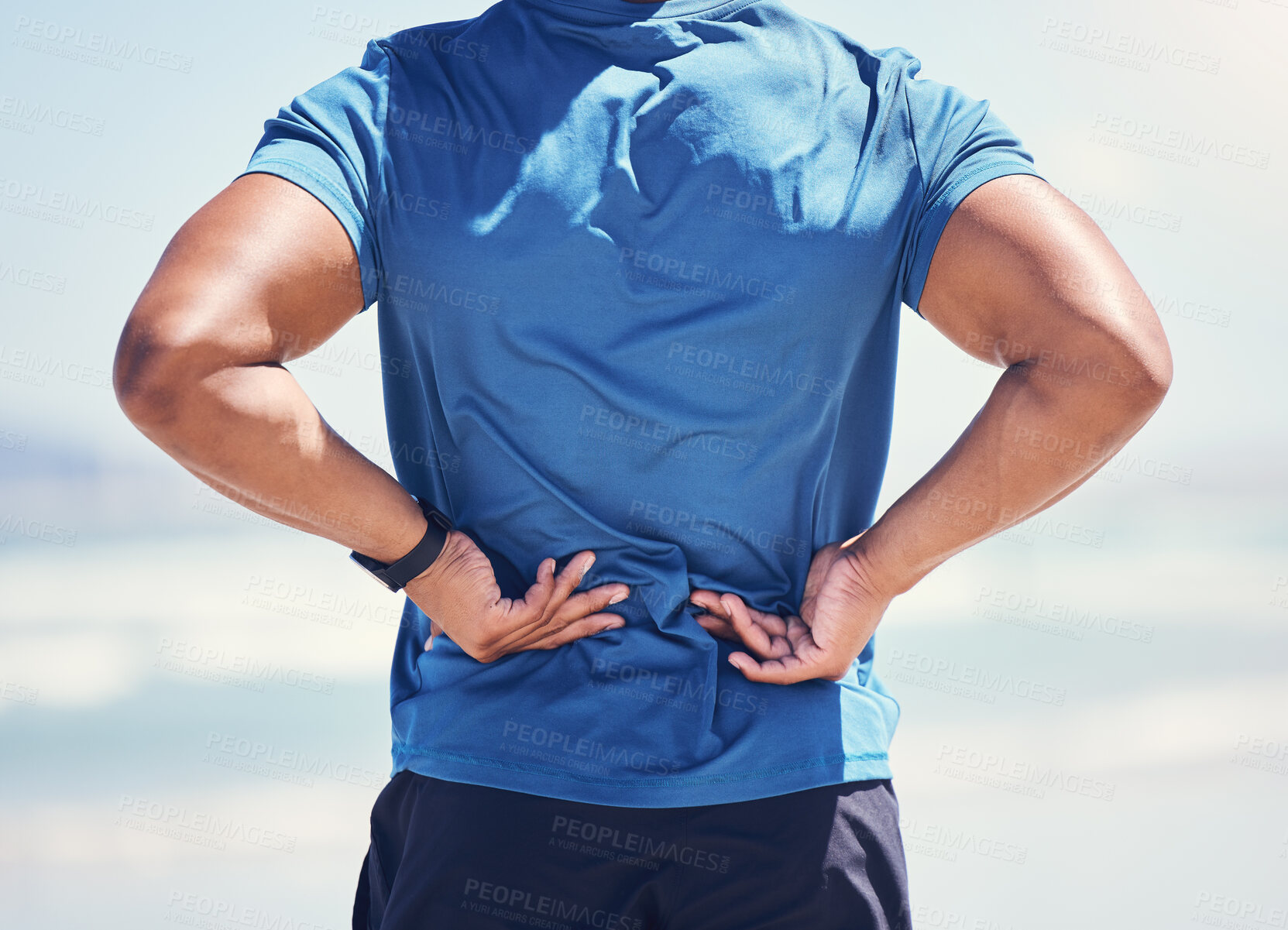 Buy stock photo Shot of a man experiencing discomfort in his back while out for a workout