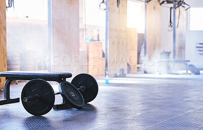 Buy stock photo Still life shot of a barbell and weight plates in an empty gym
