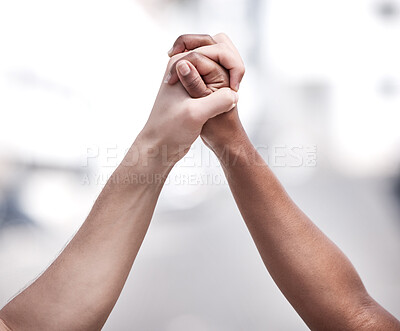 Buy stock photo Shot of two protestors joining hands in unity during a protest