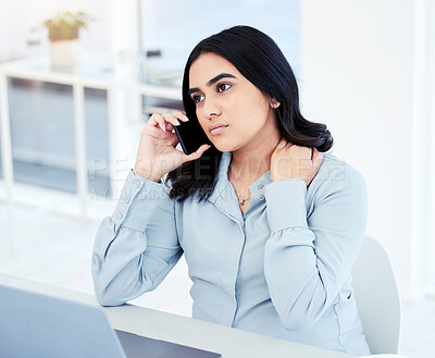 Buy stock photo Shot of a young businesswoman looking worried while talking on a cellphone in an office
