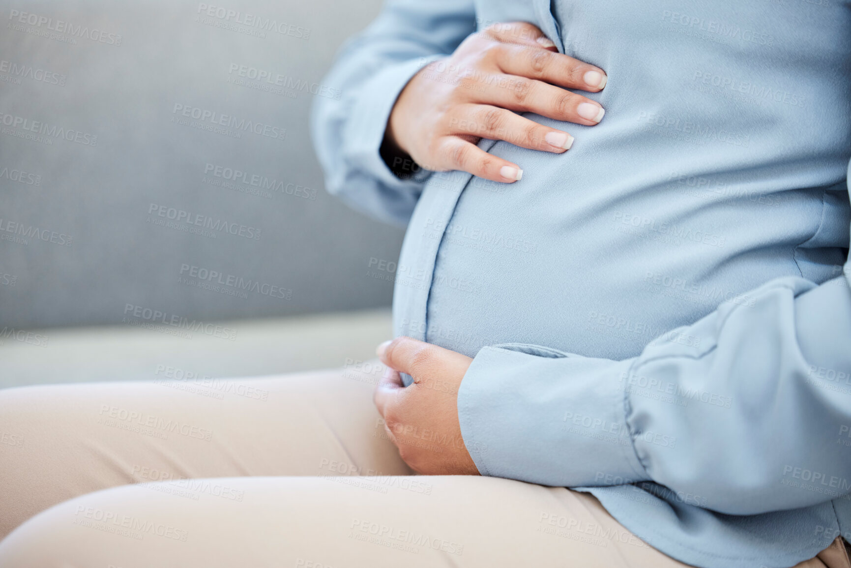 Buy stock photo Closeup, hands and pregnant woman on sofa with care, baby growth and development in maternity. Home, prenatal and expectation of female person with tummy, stomach and pregnancy for future motherhood