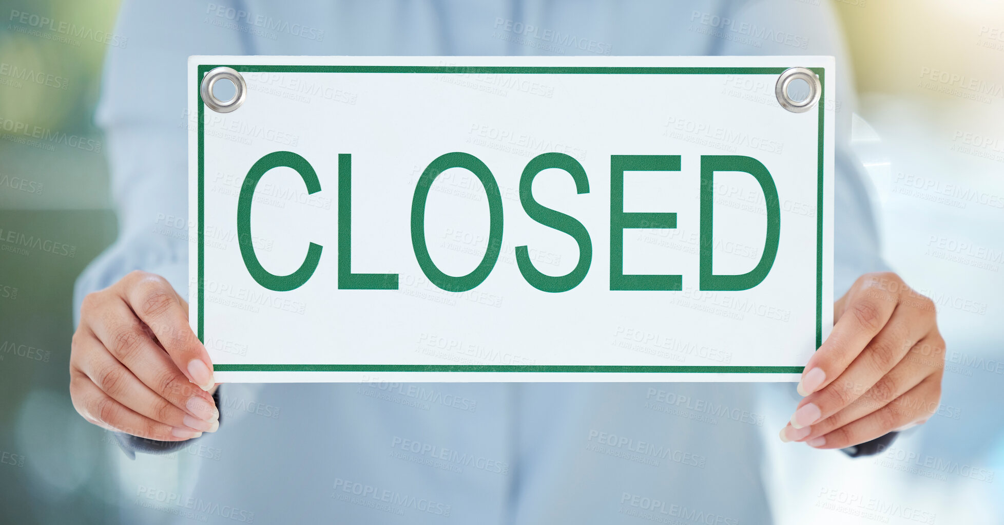 Buy stock photo Cropped shot of an unrecognizable businesswoman holding up a closed sign while standing in the office