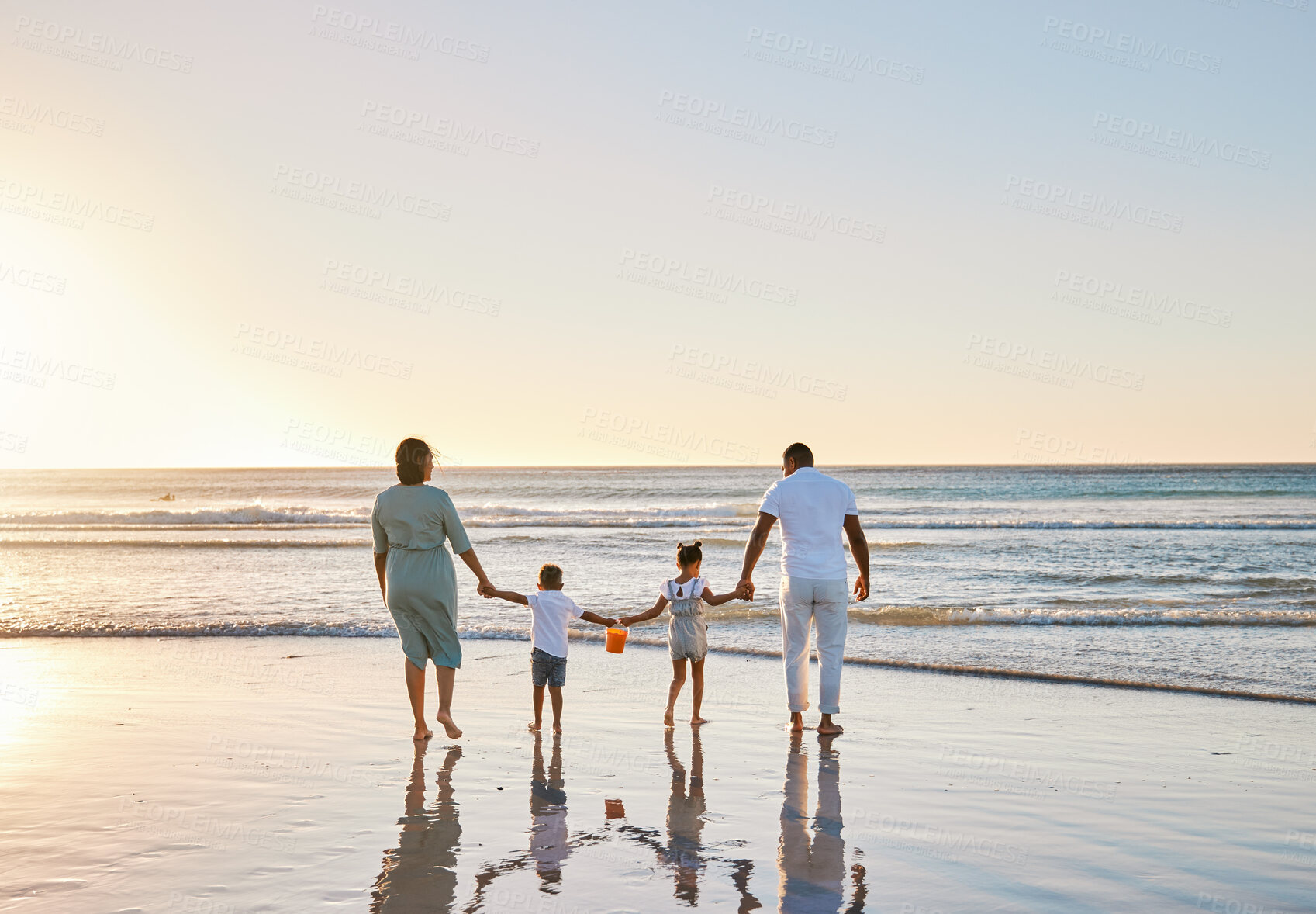 Buy stock photo Beach, parents and children with holding hands for walking, playful and bonding together on vacation holiday. Family, mother and father with kids for security, connection and sunset in ocean by back