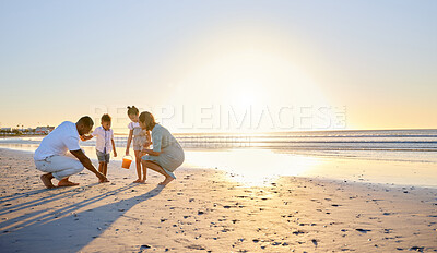 Buy stock photo Shot of a beautiful family bonding while spending a day at the beach together