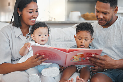 Buy stock photo Shot of a young family happily bonding together while reading a book on the sofa at home