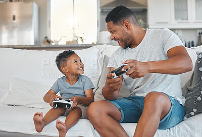 Buy stock photo Shot of a young man playing video games with his son at home