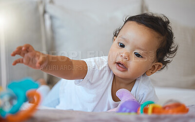 Buy stock photo Baby, girl and playing with toy on bed in home for creative imagination, sensory development and activity. Curious, child and plastic rattle in bedroom for motor skills, learning and interaction