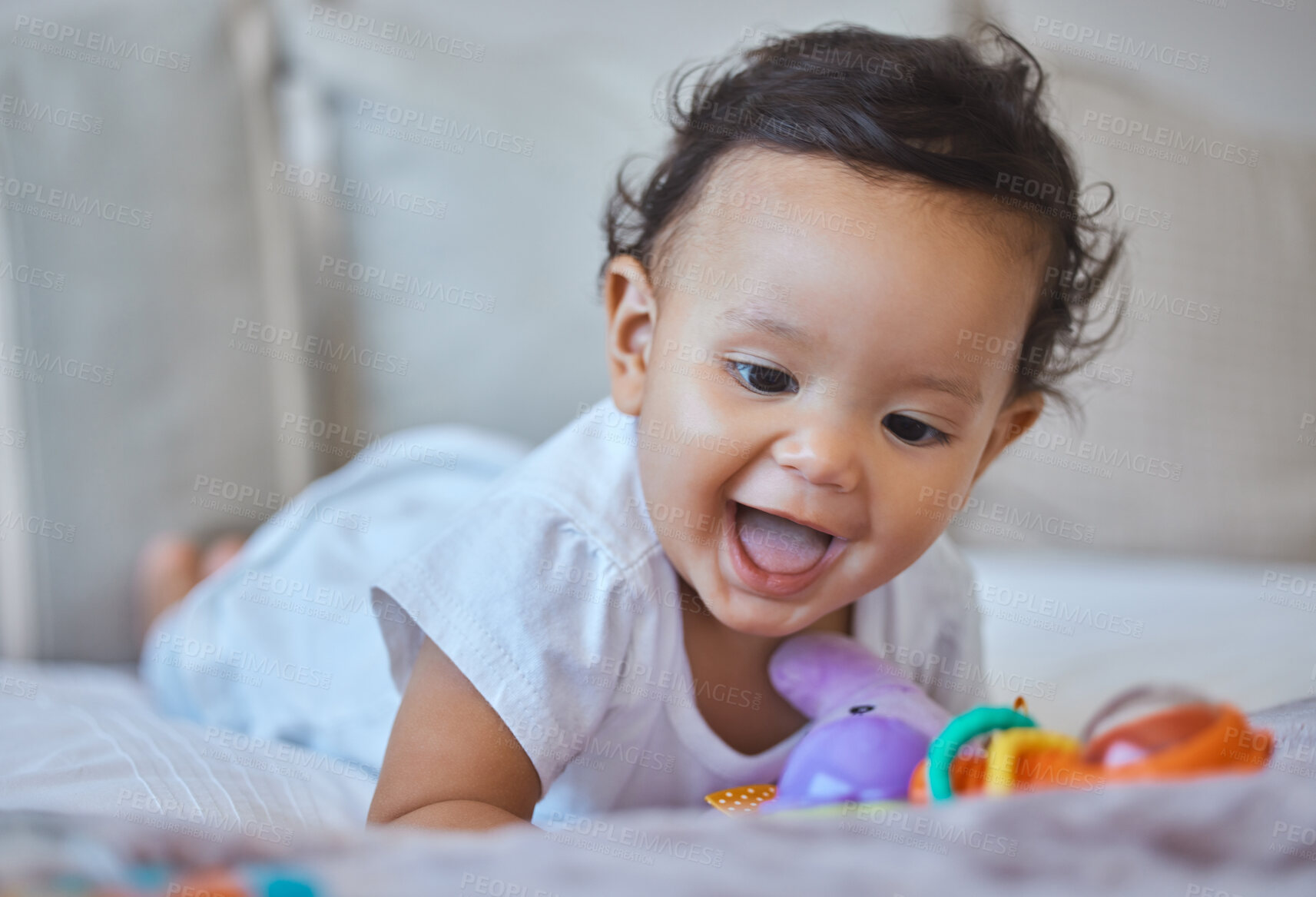 Buy stock photo Baby, child and playing with toy on bed in home for creative imagination, sensory development and activity. Curious, girl and plastic rattle in bedroom for motor skills, learning or happy interaction