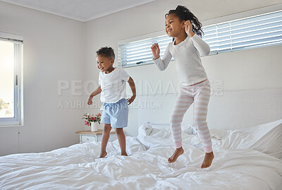 Buy stock photo Shot of an adorable little boy playing with his sister on a bed at home