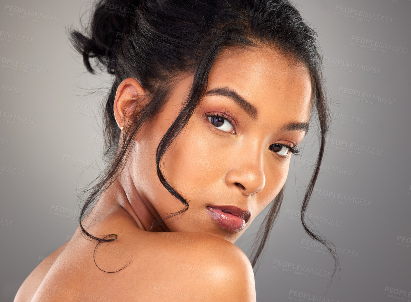 Buy stock photo Cropped portrait of an attractive young woman posing in studio against a grey background