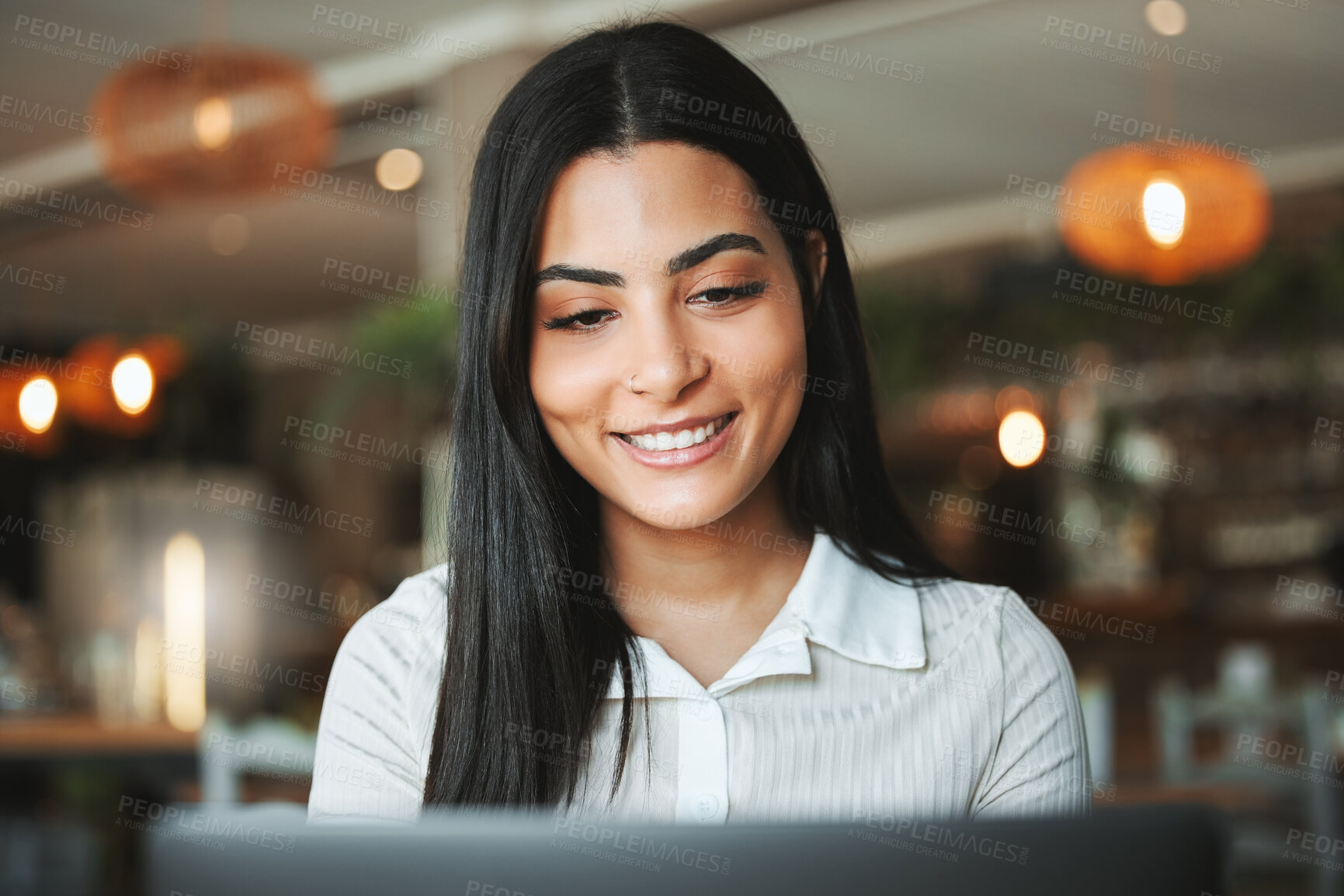 Buy stock photo Shot of a happy young businesswoman working in a coffee shop