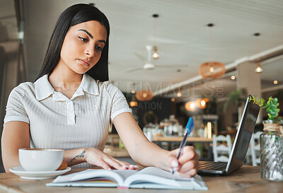 Buy stock photo Shot of a young female student working in a coffee shop