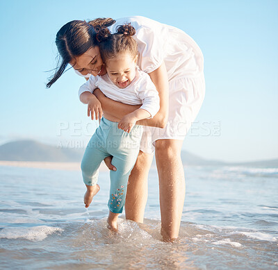 Buy stock photo Shot of a young woman at the beach with her adorable daughter