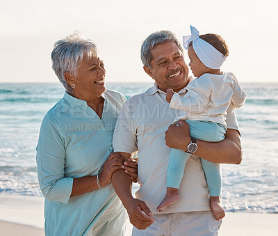 Buy stock photo Shot of a senior couple at the beach with their adorable granddaughter