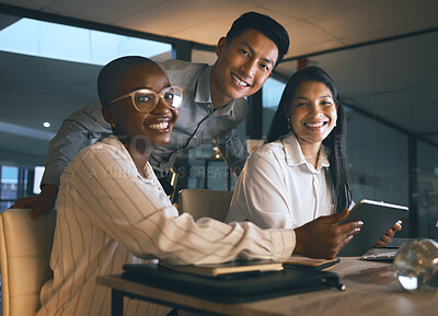 Buy stock photo Shot of a group of businesspeople using a digital tablet while working in a modern office late at night