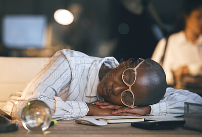 Buy stock photo Shot of a young businesswoman sleeping at her desk while working late in a modern office
