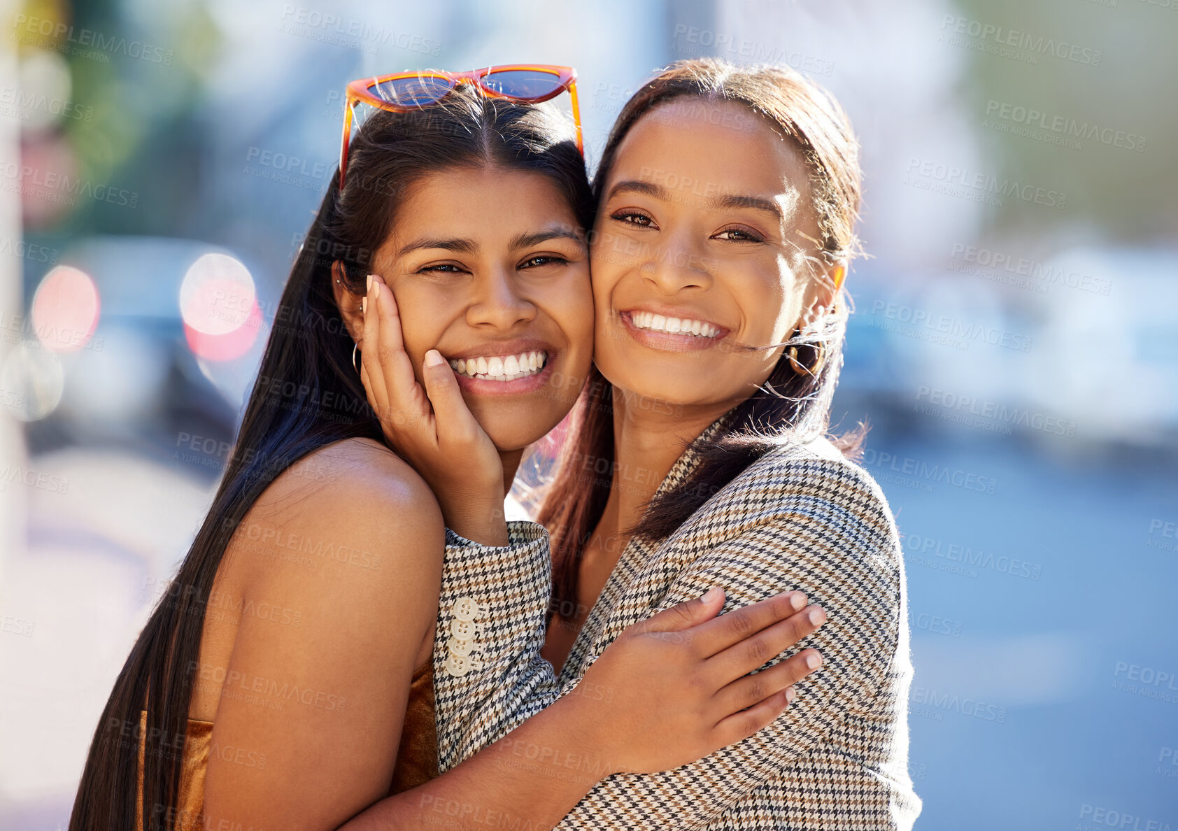 Buy stock photo Cropped portrait of two attractive young girlfriends hugging while out on the town