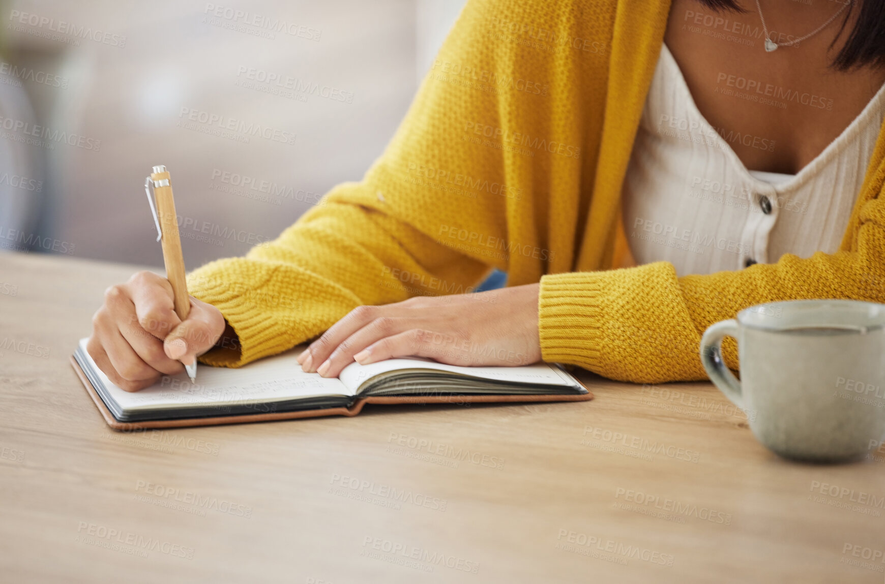 Buy stock photo Shot of an unrecognizable businesswoman writing in a notebook at home