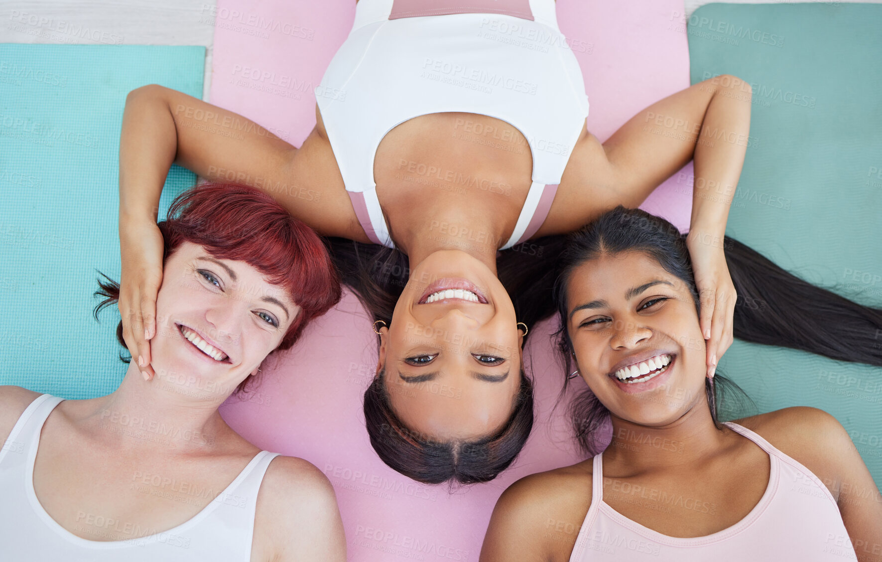 Buy stock photo High angle shot of a group of sporty women relaxing on exercise mats in a yoga studio