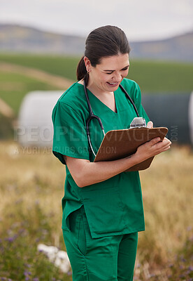 Buy stock photo Shot of a young veterinarian writing notes on a clipboard while working on a poultry farm