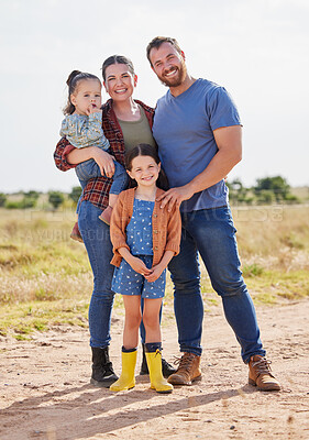 Buy stock photo Shot of a couple on a farm with their two adorable daughters