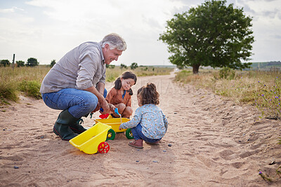 Buy stock photo Shot of two little girls playing together on a farm with their grandfather