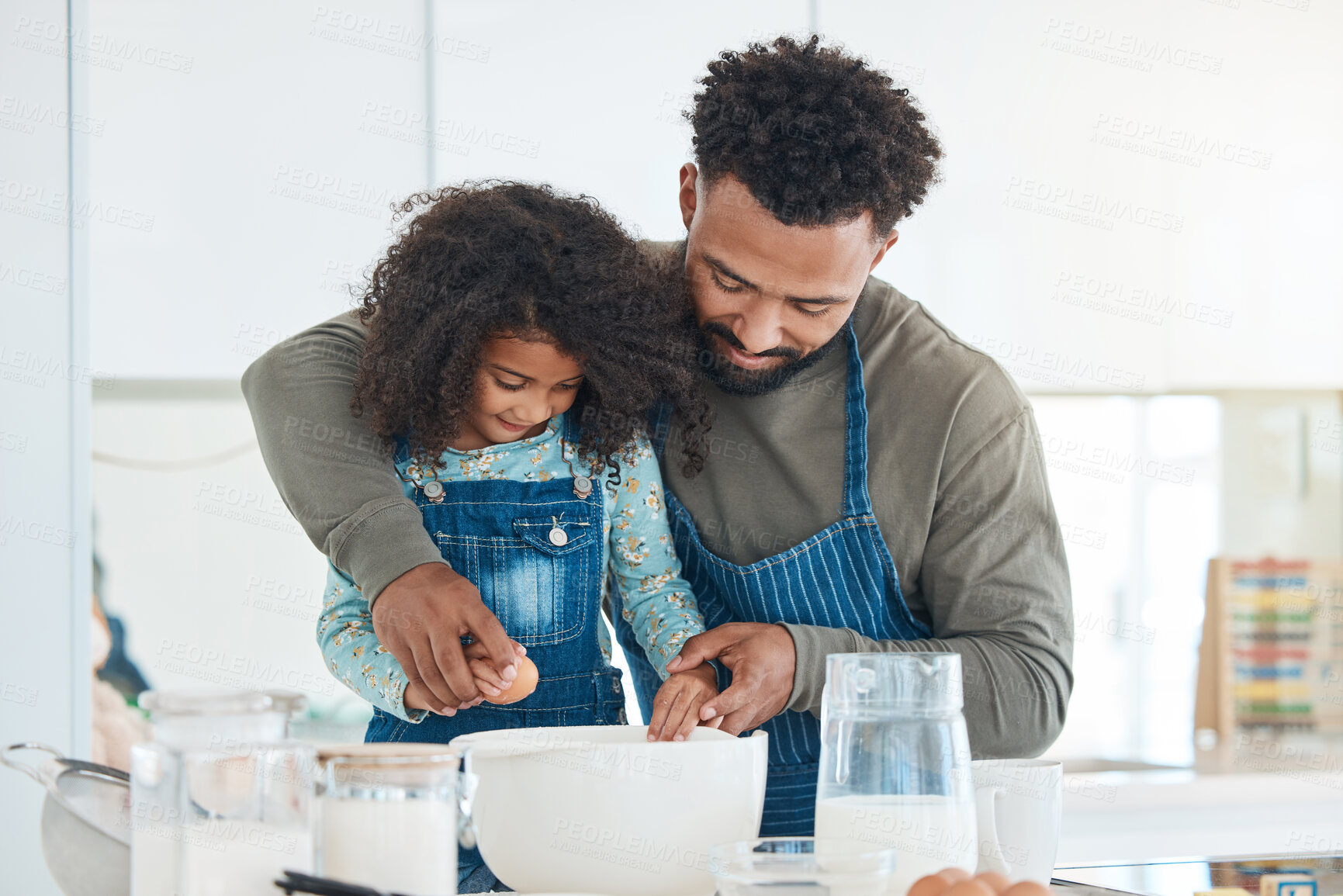 Buy stock photo Cropped shot of a handsome young man and his daughter baking in the kitchen at home