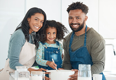 Buy stock photo Cropped portrait of an affectionate young couple and their daughter baking in the kitchen at home