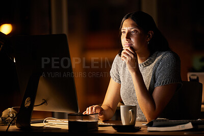 Buy stock photo Shot of a young businesswoman looking thoughtful while working on a computer in an office at night